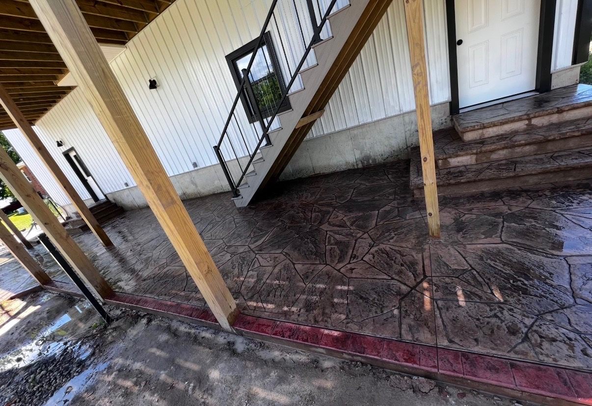 Stone-pattern concrete beneath a covered porch and staircase
