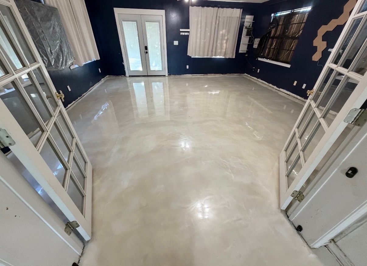 Marble-look metallic epoxy floor viewed through open interior doors