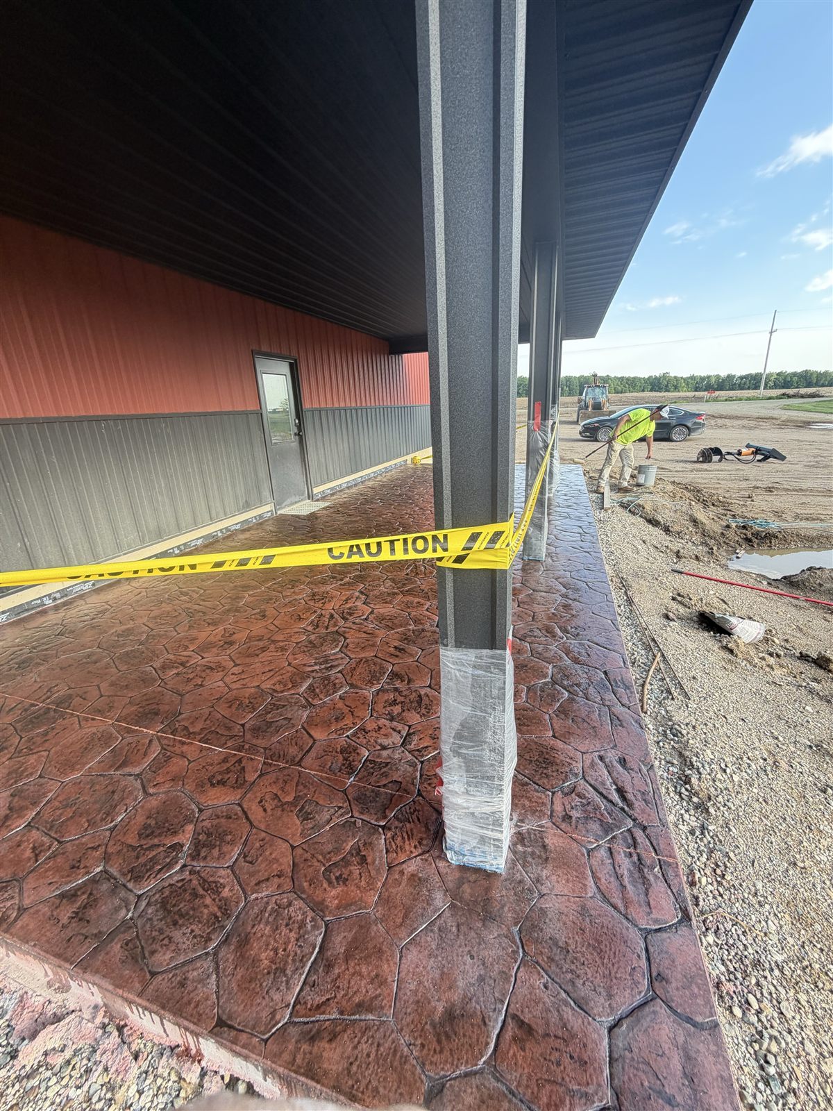 Stone-pattern concrete at a covered entry with caution tape