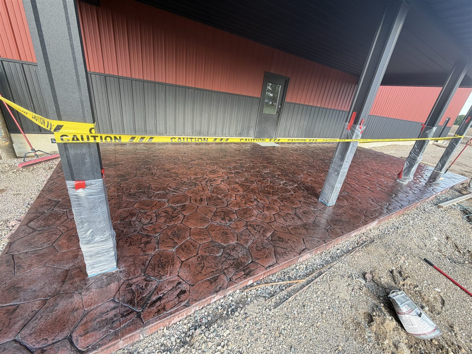 Stone-inspired pattern on red-brown concrete at a covered entrance