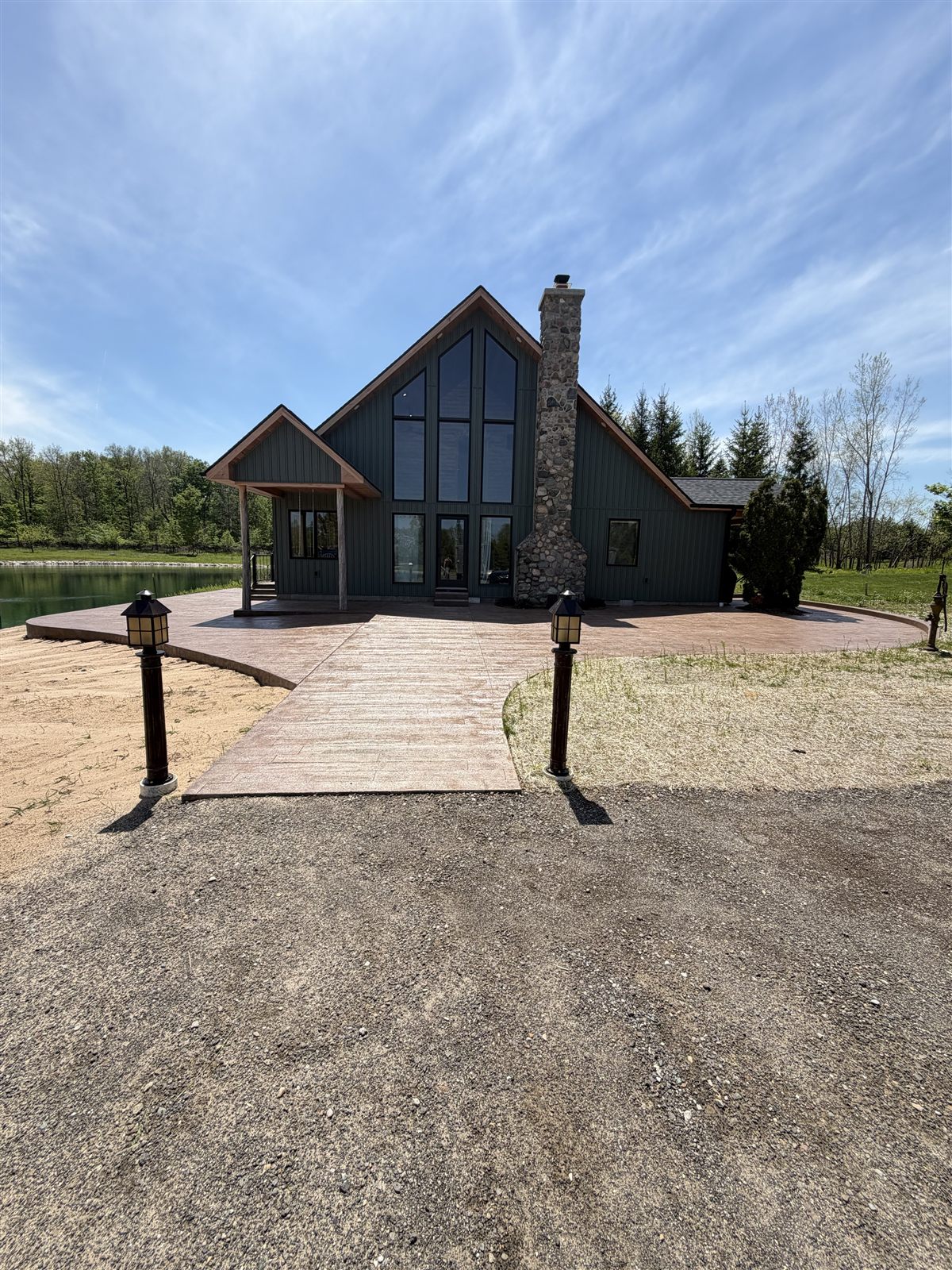 Concrete walkway leading to a cabin with a wraparound surface